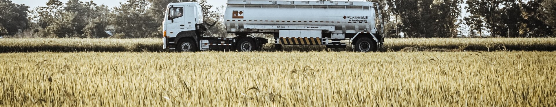 Rügenwalder Mühle Website Service: Lieferanten - LKW fährt auf Straße durch ein Kornfeld
